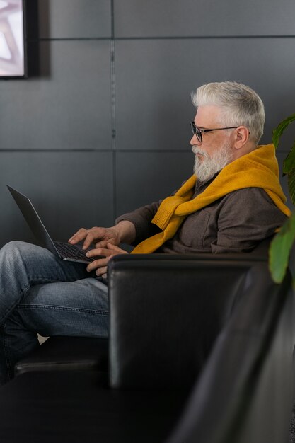 Knappe man van jaar oud met grijs haar die op een laptop werkt of online chat via videoconferenties