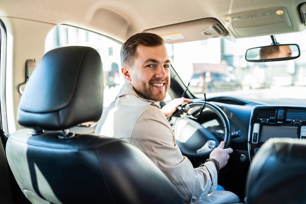 Knappe mannelijke chauffeur die terugkijkt