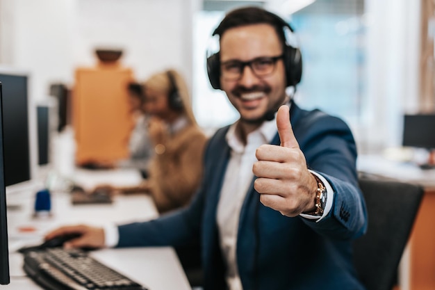 Knappe mannelijke klantenservicemedewerker met headset die in callcenter werkt.