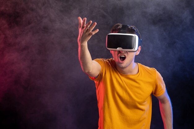 Knappe mannelijke speelspel in virtual reality op donkere ondergrond