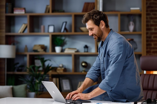 Knappe mannelijke zakenmanmanager die achter een laptop in een stijlvol thuiskantoor werkt Thuiswerk op afstand Portret van een succesvolle freelancer