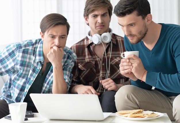 knappe mannen kijken samen naar video op laptop