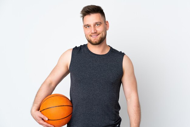 Knappe mens die op wit muur speelbasketbal wordt geïsoleerd