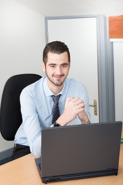 Knappe mens met laptop bij bureau in en gelukkige dag die werken