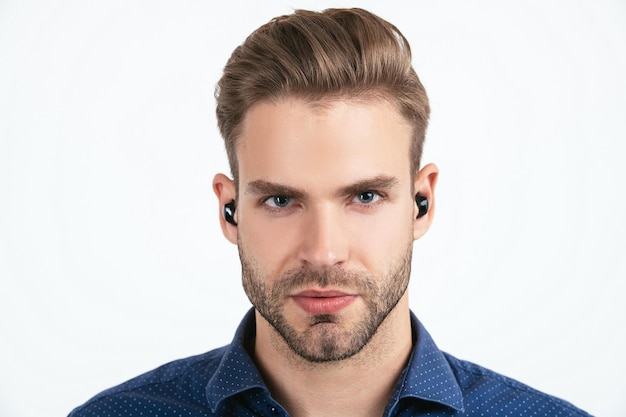 Knappe ongeschoren man met draadloze bluetooth koptelefoon geïsoleerd op wit, bluetooth headset.