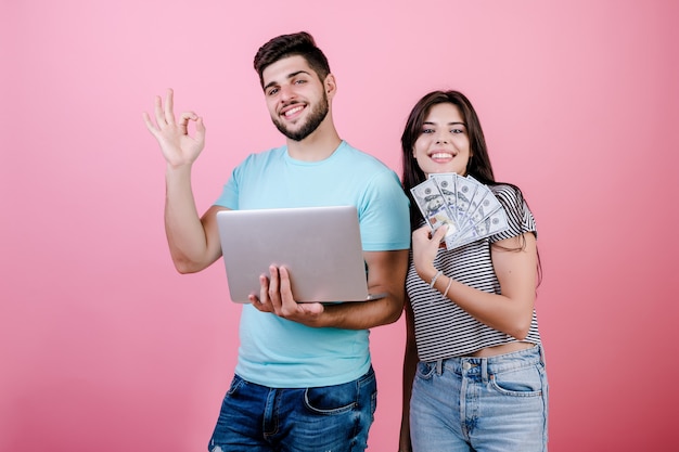 Knappe rijke jonge paarman en vrouw met laptop en dollarrekeningen