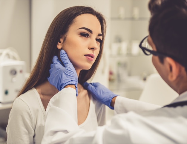 Knappe schoonheidsspecialiste onderzoekt mooie jonge vrouw.