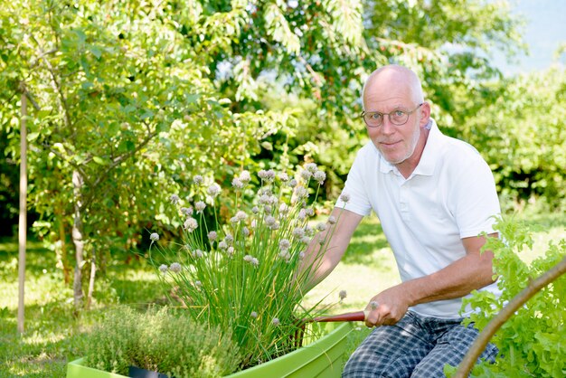 Knappe senior man in zijn tuin