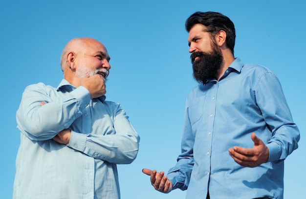 Knappe senior mannen in blauw shirt mannelijke familie van meerdere generaties wandelen gelukkige grootvader en vader