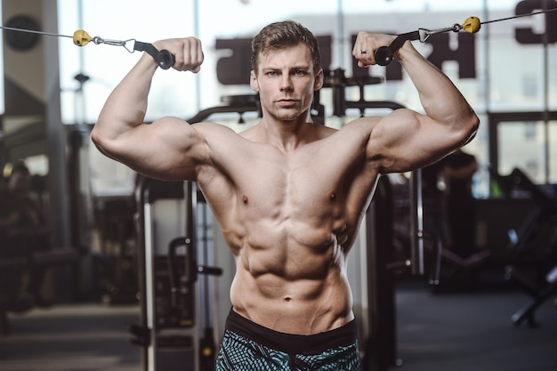 Knappe sterke bodybuilder atletische mannen oppompen van spieren met halters