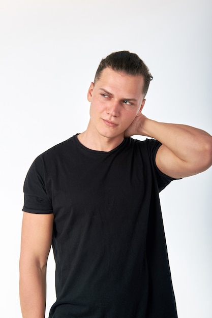 Knappe stijlvolle jongeman met een zwart katoenen t-shirt met korte mouwen poseren