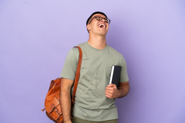 Knappe student man over geïsoleerde achtergrond lachen