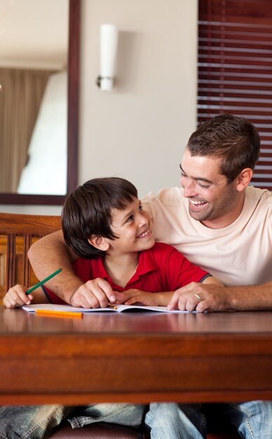 Knappe vader die zijn zoon voor thuiswerk helpt