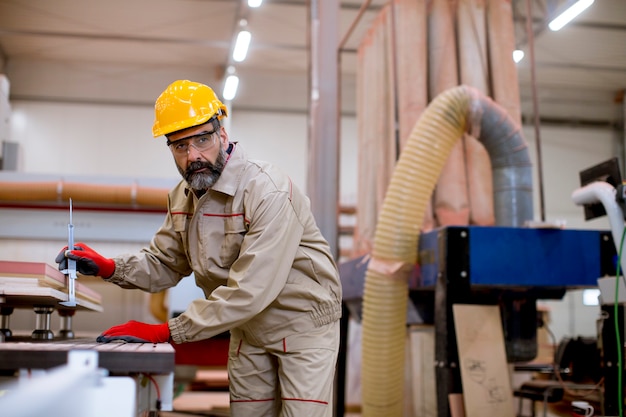 Knappe volwassen man aan het werk in de meubelfabriek