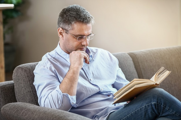 Knappe volwassen man leesboek thuis