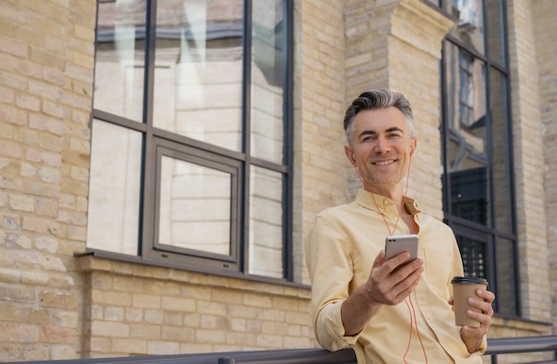 Knappe volwassen man met mobiele telefoon