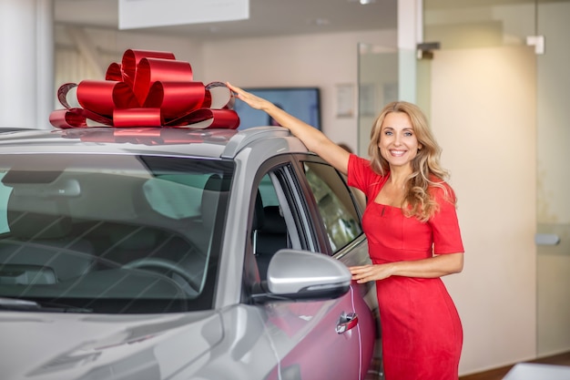 Knappe vrouw die zich verheugt over de gepresenteerde auto