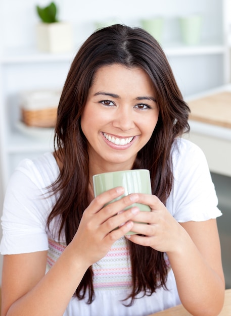 Knappe vrouw het drinken koffie in de keuken