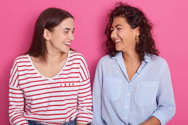 Knappe vrouwen met positieve uitdrukkingen, naar elkaar kijkend, in vrijetijdskleding