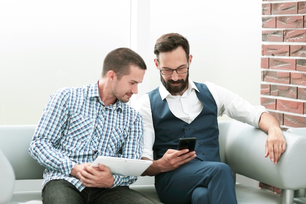 Knappe werknemer met touchpad gegevens uit te leggen aan zijn collega