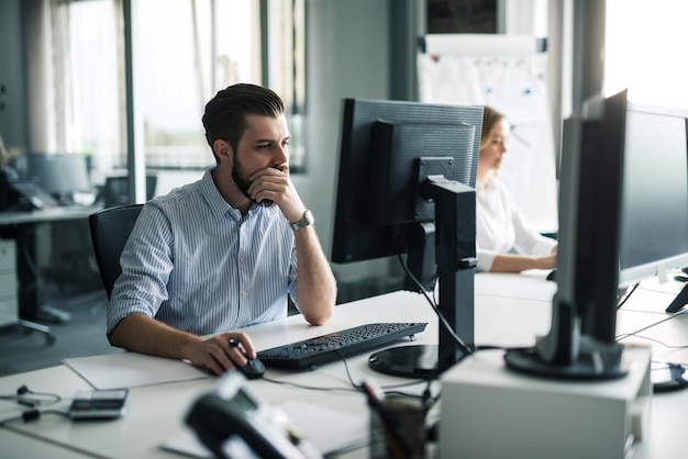 Knappe zakenman concentreerde zich op een werk op zijn computer.