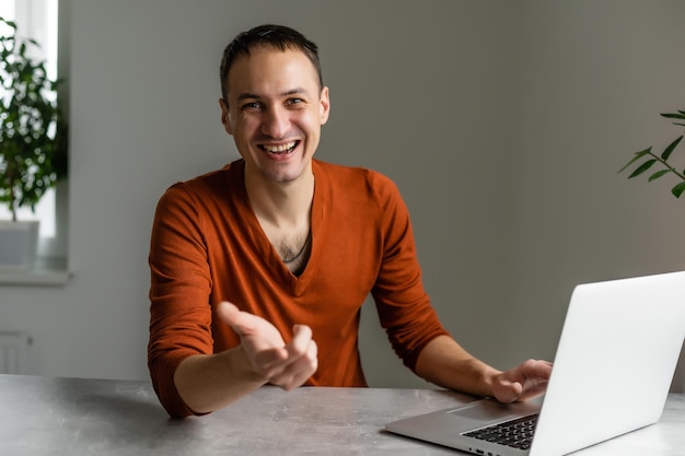 Knappe zakenman die met laptop in bureau werkt.