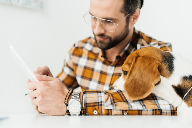 Knappe zakenman en hond die tablet bekijken