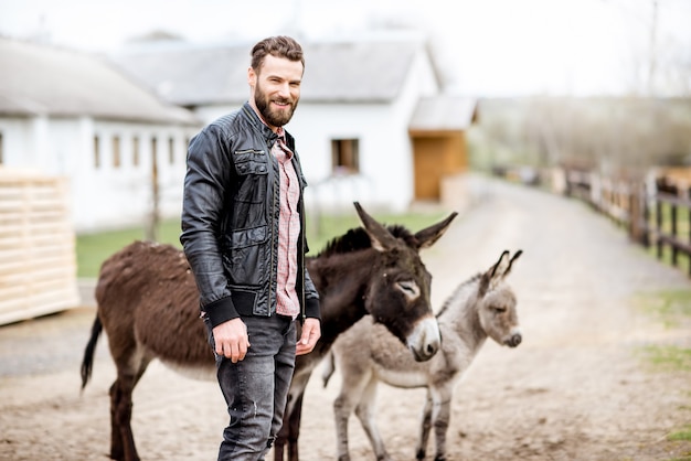 Knappe zakenman met ezels buiten het huishouden