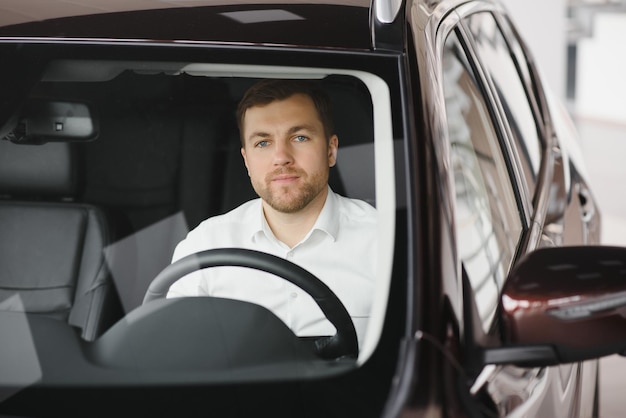 Knappe zakenman rijdende auto alvorens te kopen