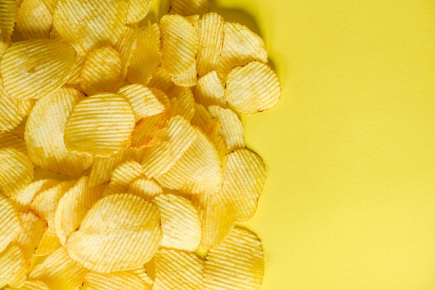 Knapperige aardappel bovenaanzicht Aardappelchips snack op gele achtergrond