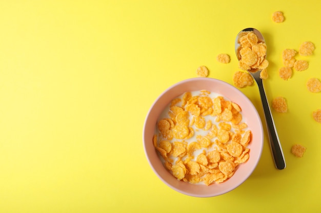 Knapperige cornflakes met melk voor ontbijt op een gekleurde close-up als achtergrond