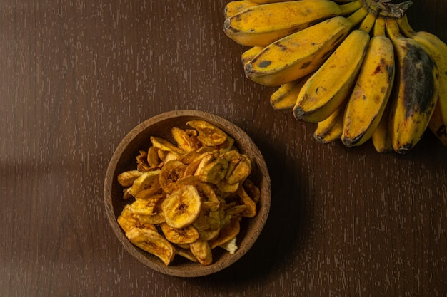 Knapperige en heerlijke bananenchips op een houten ondergrond