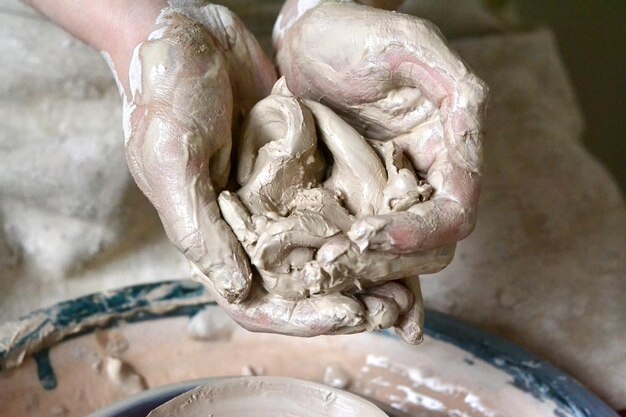Knead, raminanie clay in the hands of the man close up