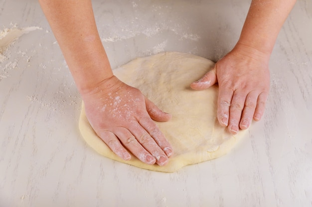 Kneading pizza dough for pizza making.