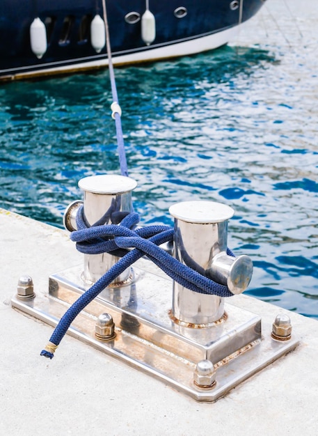 Foto knecht ancoraggio su una marina con una corda blu legata vicino