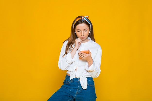 Knee figure of young beautiful caucasian woman listening music with headphones dancing smiling