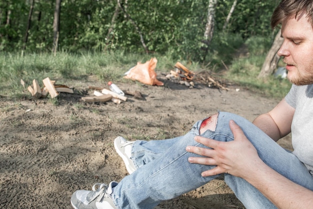 Foto knie met bloederige wond close-up gescheurde jeans