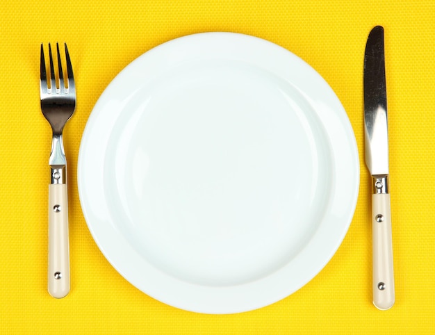 Knife color plate and fork on color background