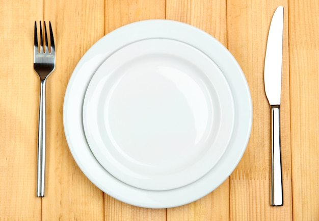 Knife, color plate and fork, on wooden table