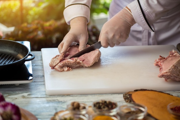 Knife cuts raw meat. Chef's hands in white gloves. What to prepare from pork. Cook will demonstrate skills.