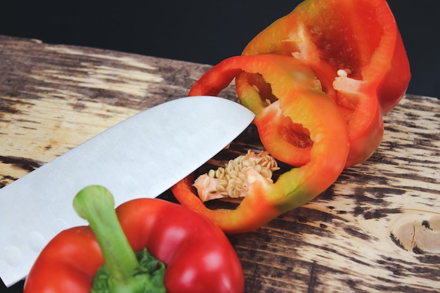 Knife cutting a pepper Cook on a wooden board slices pepper closeup macro