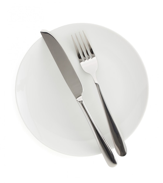 knife and fork on a plate on white background