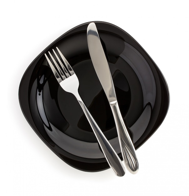 knife and fork on a plate on white background