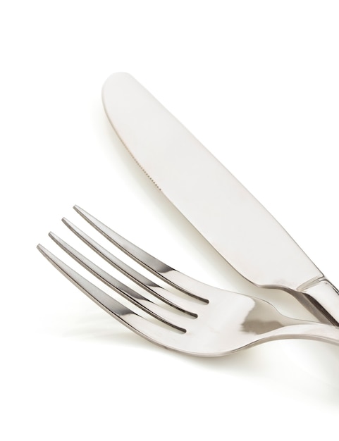 Knife and fork on white wall