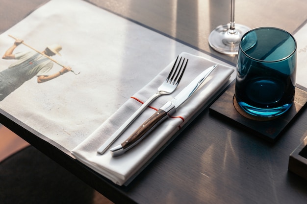 Knife and fork with napkin on wooden table for fine dining