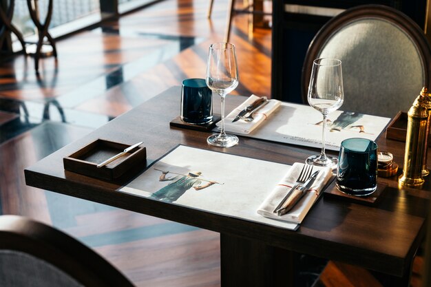 Knife and fork with napkin on wooden table for fine dining