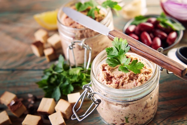 Knife placed on jars of homemade bean pate on table