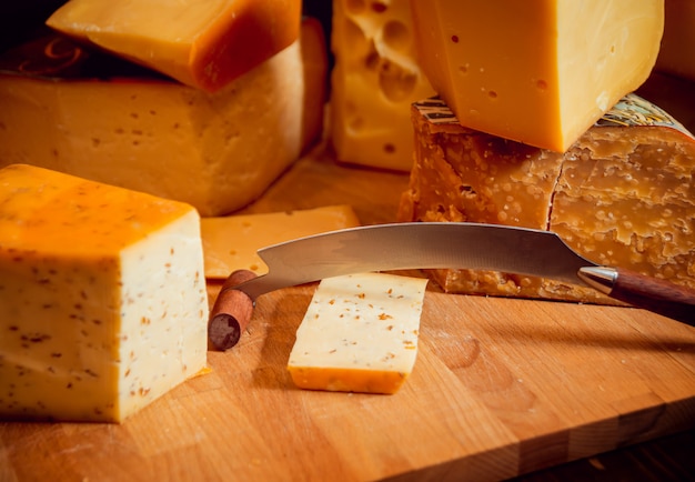 Knife with piece of cheese on a dark table