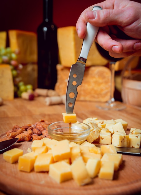 Foto coltello con pezzo di formaggio su un tavolo scuro