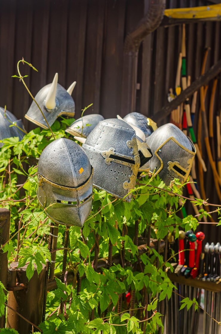 Photo knights helmet made of steel on a wooden fence with green leaves high quality photo